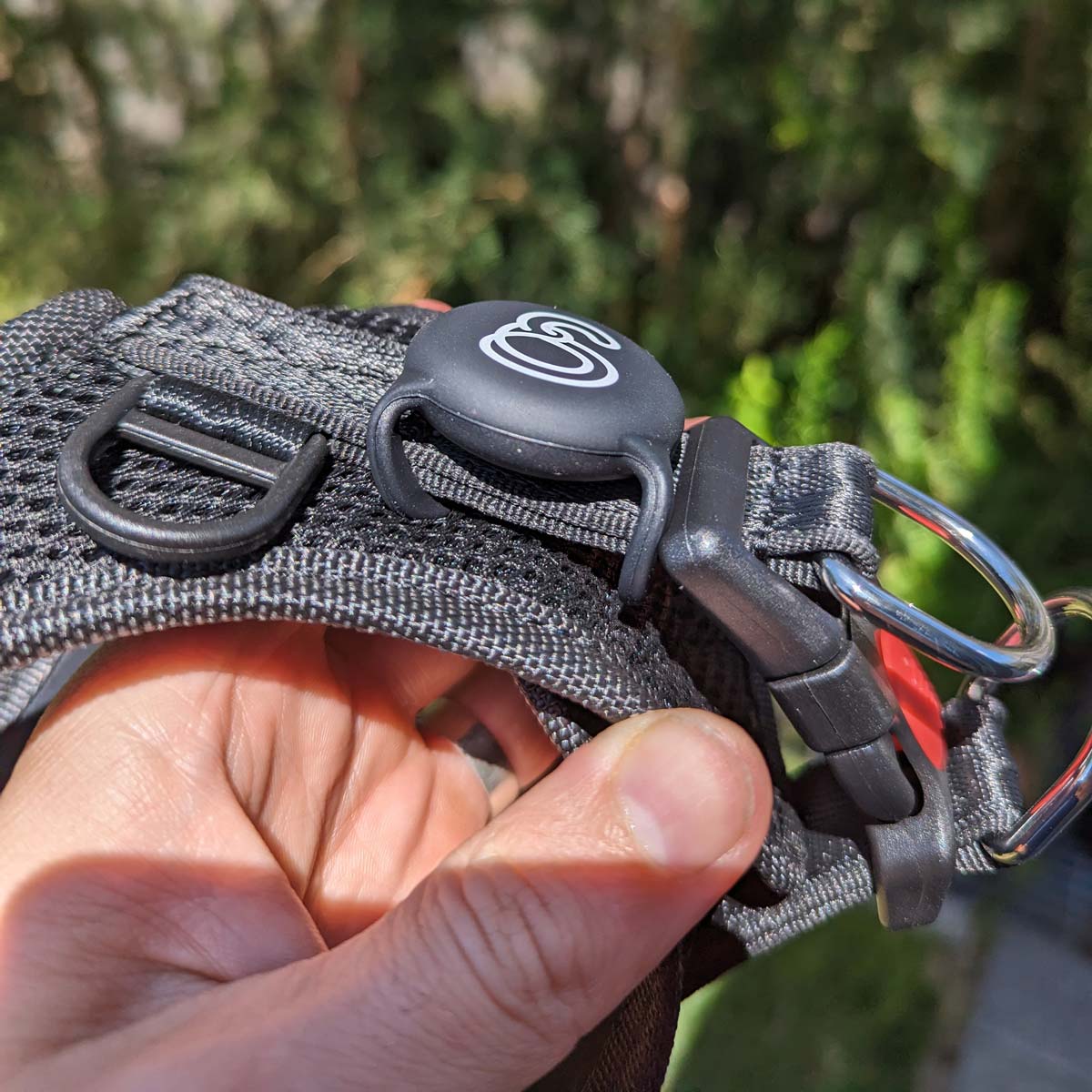 Black Apple Airtag Holder, attached to harness