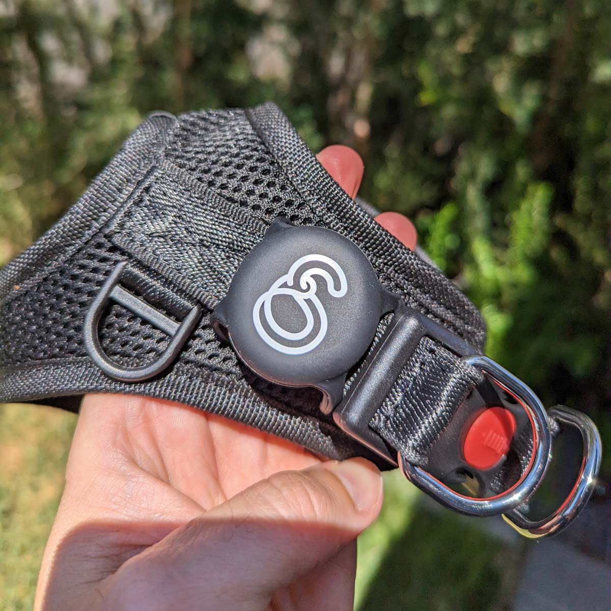Black Apple Airtag Holder, attached to harness