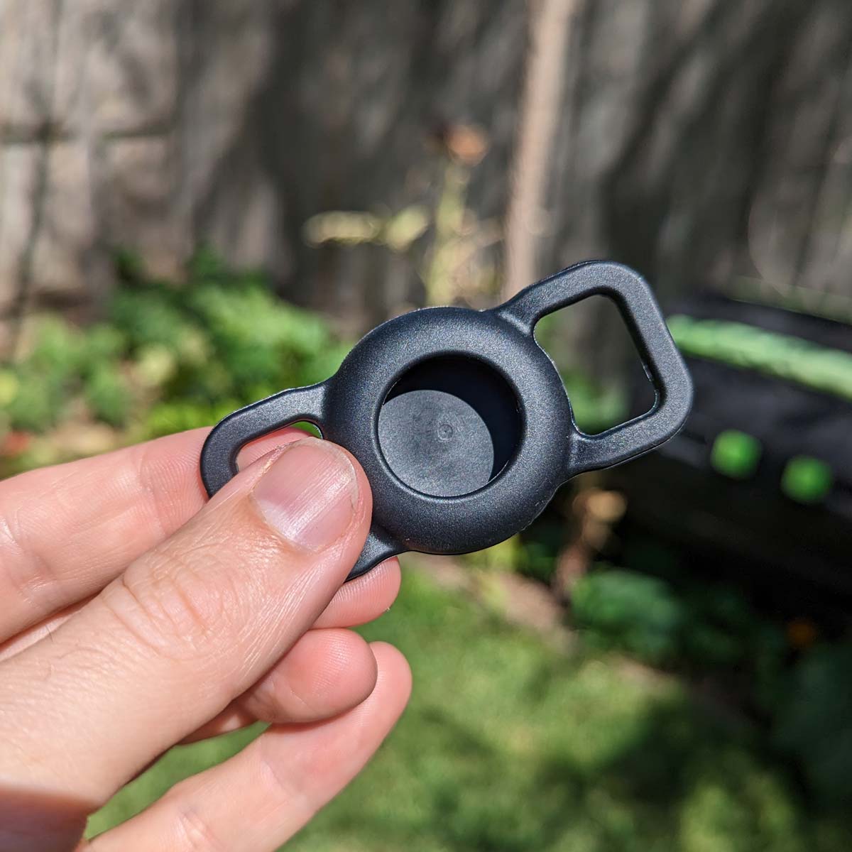 Black Apple Airtag Holder, held by a hand