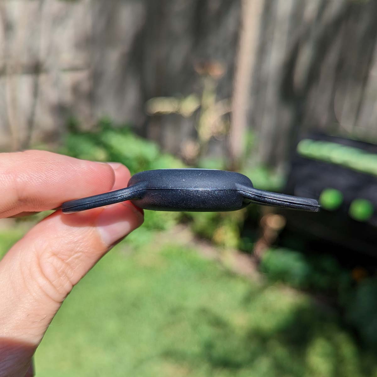 Black Apple Airtag Holder, held by a hand